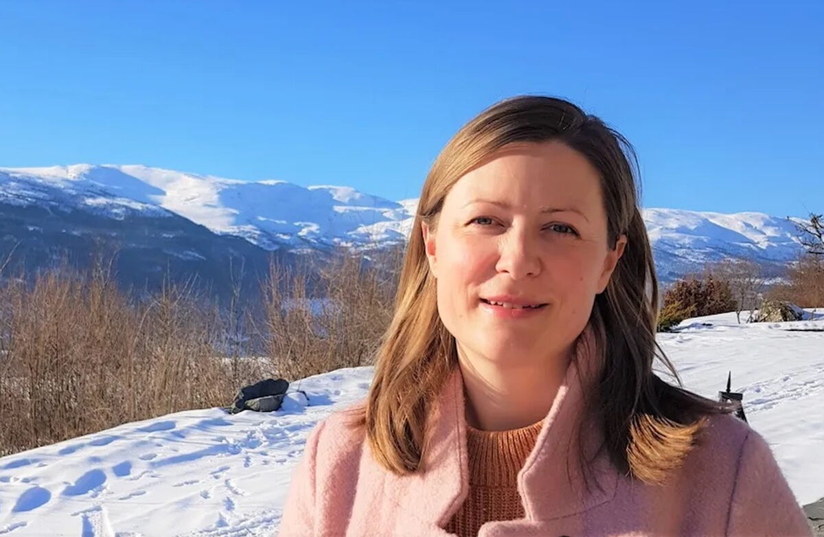 Sigrid er gunnleggeren av samhandlingsplattformen friskus.com – en digital infrastruktur for aktivitet og deltakelse i lokalsamfunn. Hun har blitt kåret til en av Norges 50 fremste tech-kvinner to år på rad og vant eHelseprisen 2025. Foto: Privat Ung kvinne ute i naturen. Fjell med snø på i bakgrunnen.