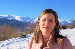 Sigrid er gunnleggeren av samhandlingsplattformen friskus.com – en digital infrastruktur for aktivitet og deltakelse i lokalsamfunn. Hun har blitt kåret til en av Norges 50 fremste tech-kvinner to år på rad og vant eHelseprisen 2025. Foto: Privat Ung kvinne ute i naturen. Fjell med snø på i bakgrunnen.