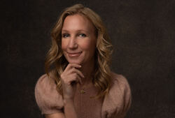 – Vi må bli dydige teknologer. Ledere som både forstår verktøyene og insisterer på formålet. Som setter menneskelige verdier inn i teknologiutviklingen, ikke etterpå, men fra start, sier Elisabeth-Austad-Asser. Foto: Mona Hauglid Kvinne med langt lyst hår, en hånd under haken, ser tenksomt mot kamera