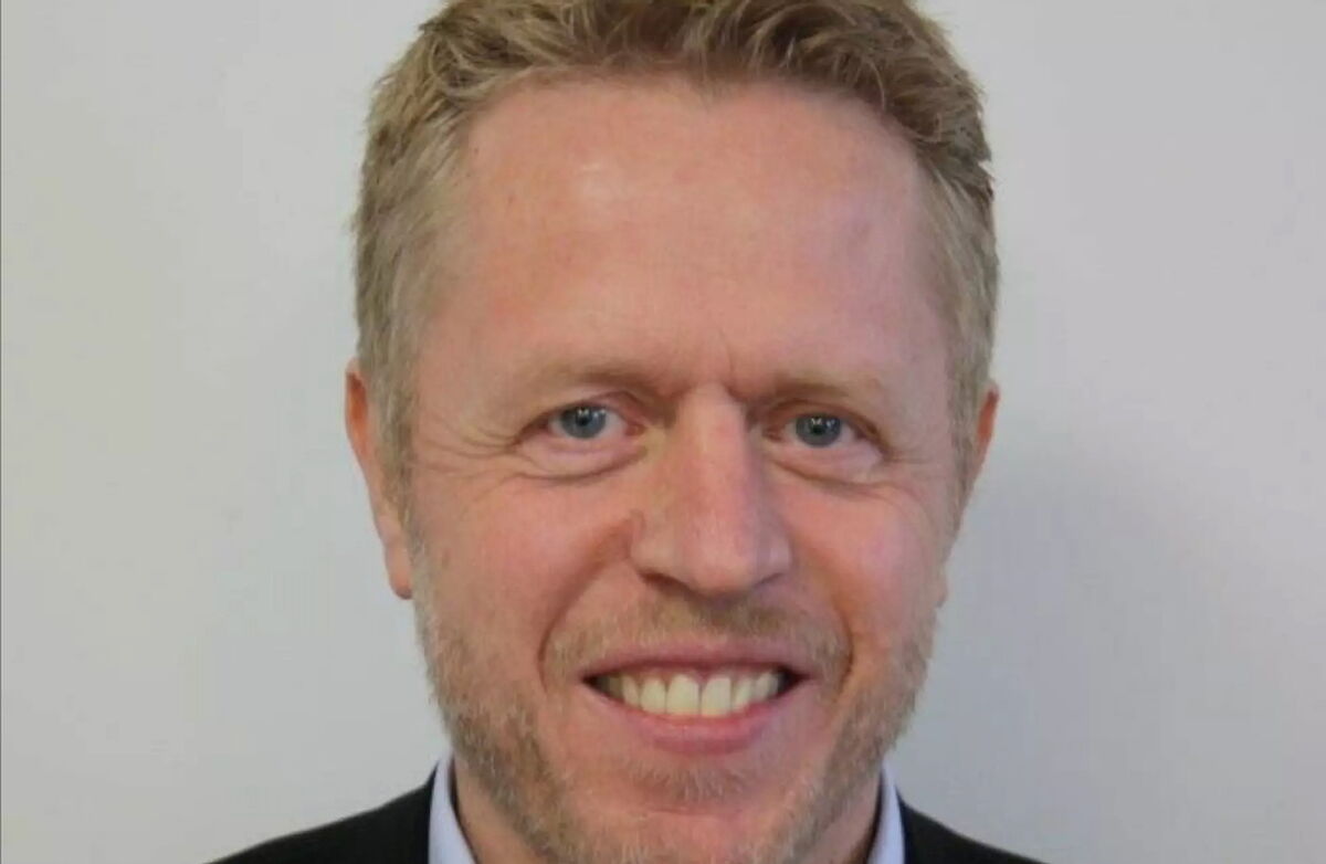 Middelaldrende mann med krøller i håret, smiler