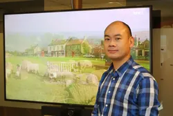 Kinesisk mann nesten uten hår og med rutete sjorte.