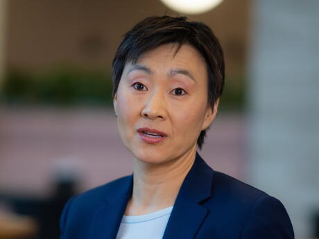 Kvinne med asiatisk utseende i blå dressjakke.