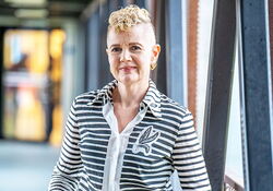 Kvinne med lyst hår og stripete genser