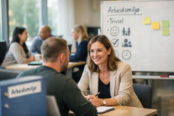 En kvinne i samtale med en mann om arbeidsmiljø og trivsel