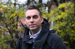 Bildet viseer Hans Christoffer Aargaard Terjesen. Middelaldrende mann utendørs med løvtrær i bakgrunnen. Han ser våkent mot deg.