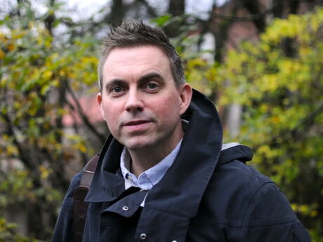 Bildet viseer Hans Christoffer Aargaard Terjesen. Middelaldrende mann utendørs med løvtrær i bakgrunnen. Han ser våkent mot deg.