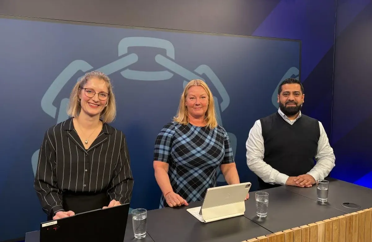 De står bak en disk med PC og iPAD.