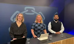 De står bak en disk med PC og iPAD.