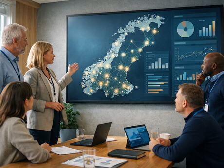 Personene er samlet foran et norgeskart, som viser steder med digitaliseringstiltak.