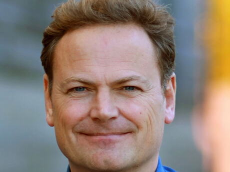 Mann ser alvorlig inn i kameraet