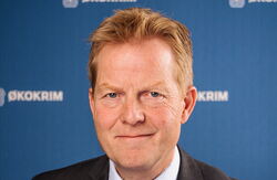 Alvorlig middelaldrende mann ser inn i kameraet.