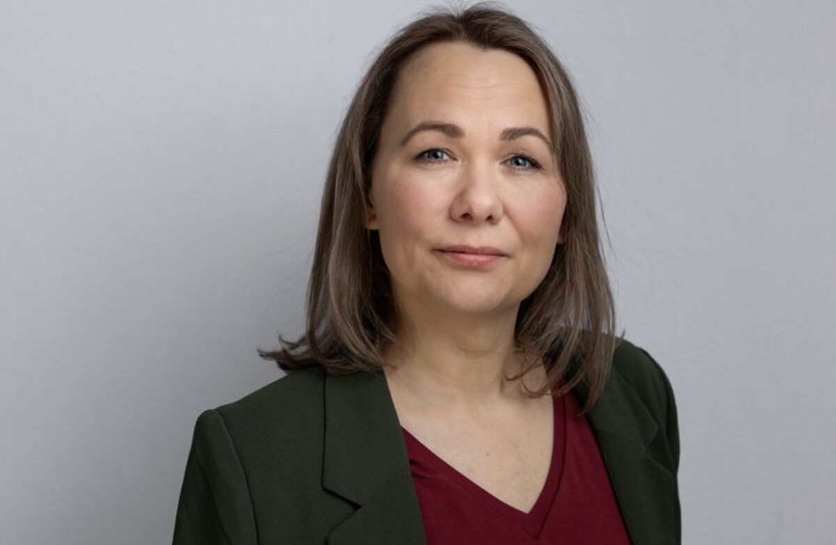 – Den raske digitaliseringa i samfunnet gjer det krevjande for mange eldre å henge med. Digital kompetanse og tilgang til digitale hjelpemidlar er viktig for å kunne delta i en stadig meir digitalisert kvardag, seier Nina Myklebust. Foto: Nina Rangøy Kvinne med mørkt blondt hår, midtskill, dressjakke og burgunder V-genser ser alvorlig inn i kameraet.