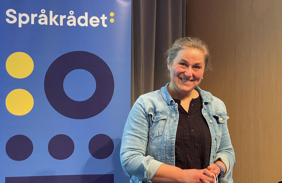 Olaug Nilssen sitt innlegg var ei påminning om at offentleg språk aldri berre er språk. Det blir lese av menneske med kropp, historie, frykt og håp. Det var mange som sat att med tårer i augo då det var over. Foto: Torbjørn Vinje Middelaldrende kvinne med håret i hestehale ser mot fotografen. Hun har på en lyseblå jakke i dongeristoff.