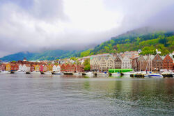 Bryggen i Bergen med de karakteristiske husene mot vannet. Det er skodde og en særegen stemning.