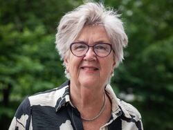 Eldre kvinne halvkort grått hår med grønn bakgrunn