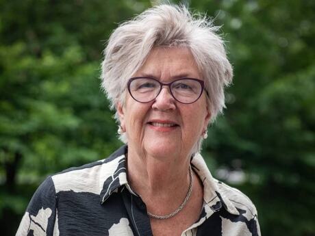 Eldre kvinne halvkort grått hår med grønn bakgrunn