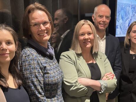 Fire kvinner og en mann ser mot kameraet. En har armene i kors, noen smiler.