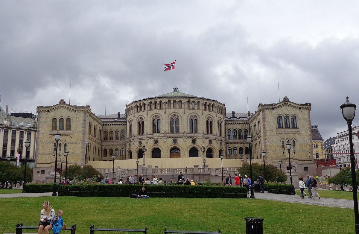 Stortingsbygningen, med en mor og et barn i forgrunnen.