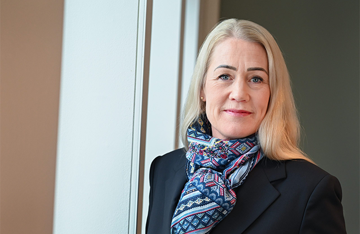 Kvinne med lyst hår ser inn i kameraet.