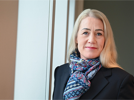 Kvinne med lyst hår ser inn i kameraet.