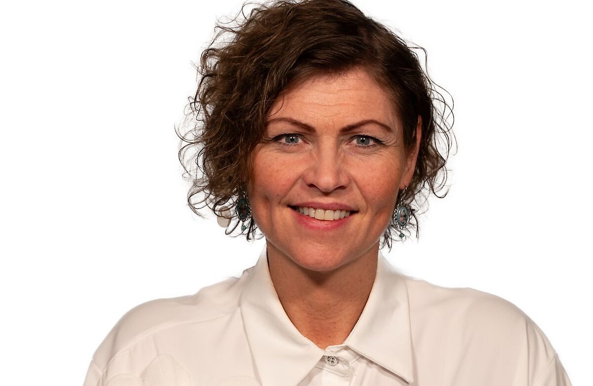 Bildet viser en smilende Jakobe Juul i hvit bluse.