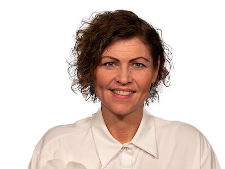 Bildet viser en smilende Jakobe Juul i hvit bluse.