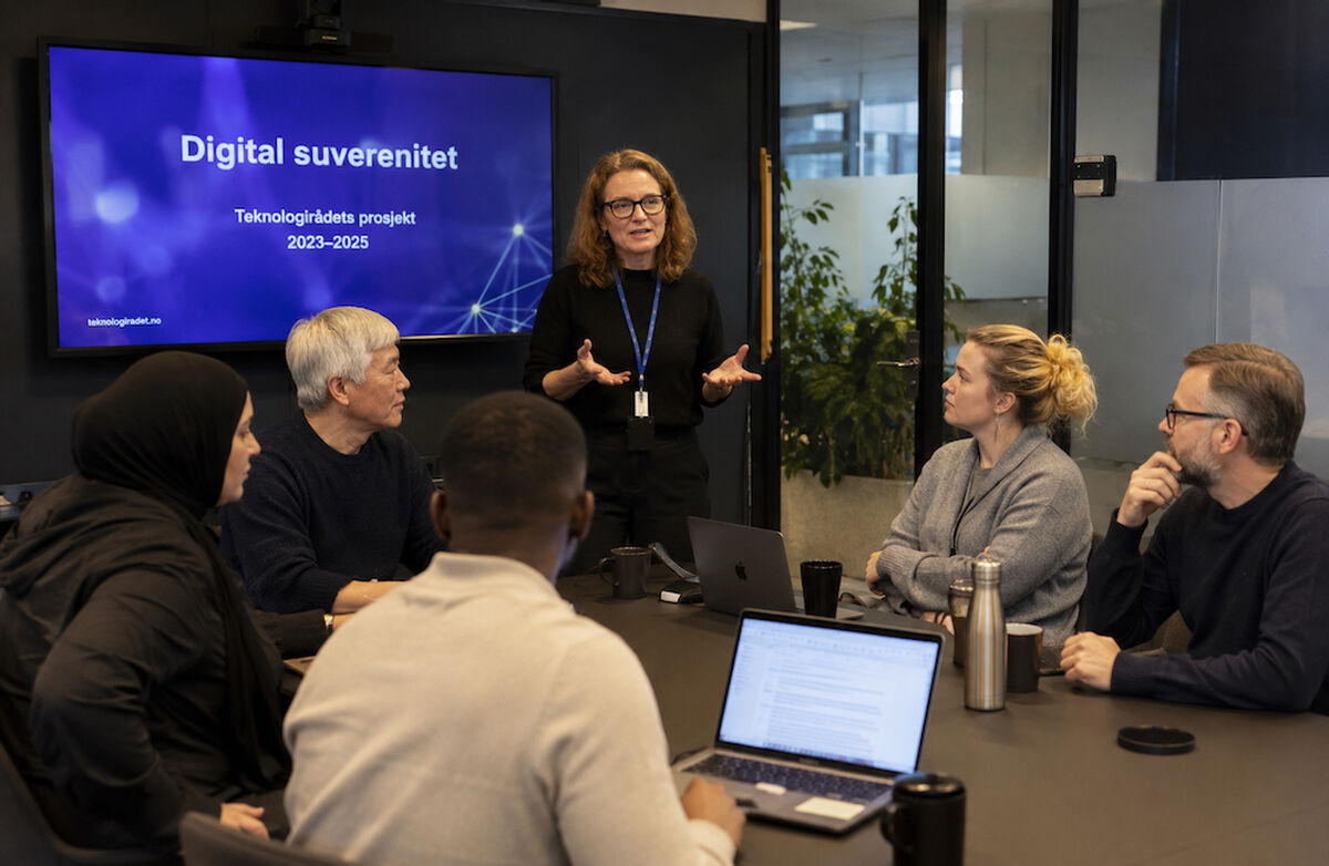 Teknologirådet vil i dette prosjektet vurdere hva digital suverenitet kan bety for Norge, og hvilket handlingsrom vi har. Illustrasjonsfoto: KI-generert Et mangfoldig møte om digital suverenitet, der deltakere diskuterer teknologi, datasikkerhet og nasjonal kontroll over digital infrastruktur.