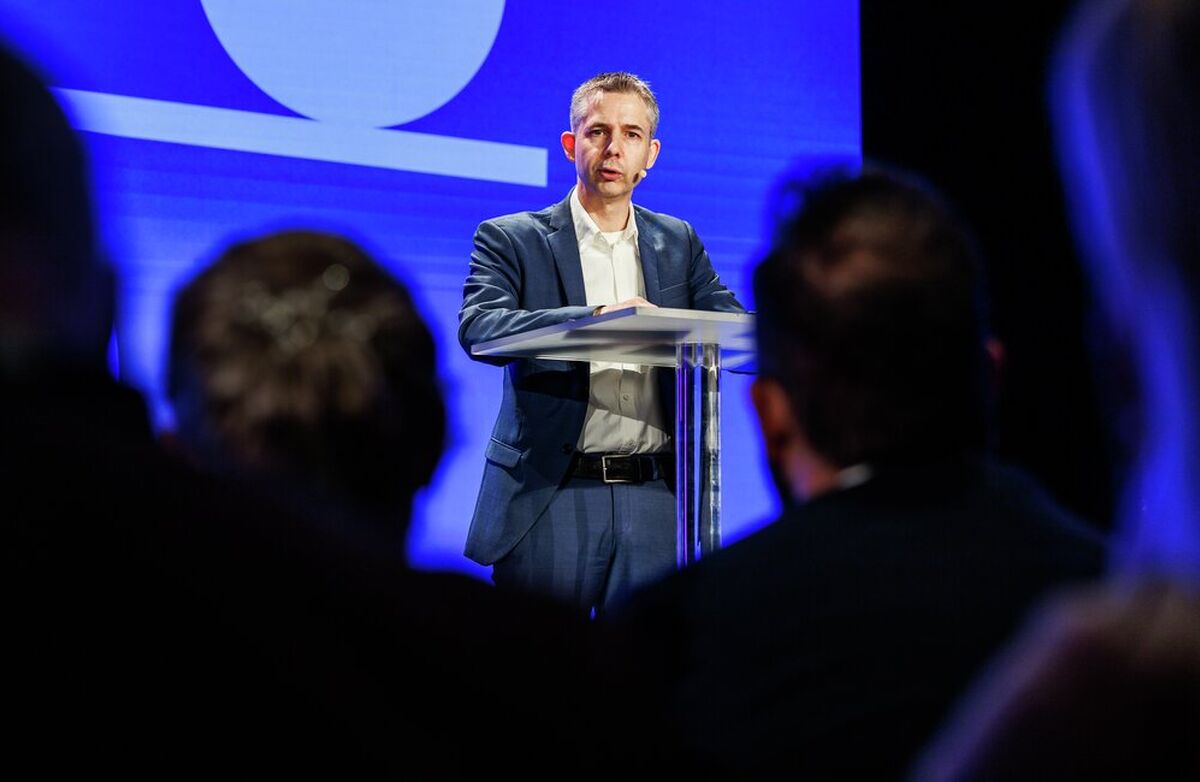 For Frode Danielsen er kunstig intelligens ikke noe Norge kan håndtere stykkevis og delt. Skal landet lykkes, må fundamentet styrkes, kompetansen bygges, risikoen tas på alvor og offentlig og privat sektor trekke i samme retning. Foto: Kilian Munch, Digitaliseringskonferansen Middelaldrende mann på scenen, sett forfra og med de mørke bakhodene til en del deltakere i forgrunnen.