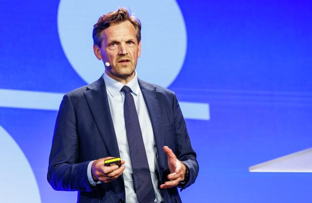 Budskapet fra Inge Svae-Grotli var at kriminaliteten allerede bruker teknologi, tempo og nettverk på en måte som utfordrer samfunnets vern. Skal rettsstaten beskyttes, må offentlig og privat sektor dele mer, handle raskere og bruke teknologien mer målrettet. Foto: Kilian Munch, Digitaliseringskonferansen Alvorlig middelaldrende mann på scenen i dress.