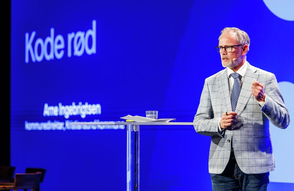 Arne Ingebrigtsens hovedbudskapi var at KI ikke bare utfordrer hvordan offentlig sektor utvikler digitale løsninger. Den utfordrer hele modellen for anskaffelse, forvaltning, ansvar og styring. Foto: Kilian Munch, Digitaliseringskonferansen Eldre mann i rutete dressjakke på scenen