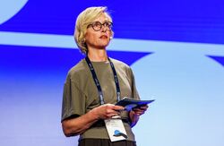 Lajla Ellingsens hovedbudskap var at datadeling ikke bare handler om effektivisering eller teknologi. Det handler om offentlig kontroll, demokrati, konkurranse, innovasjon og Norges evne til å bruke egne ressurser før andre gjør det. Foto: Kilian Munch, Digitaliseringskonferansen Kvinne med lyst hår på scenen.