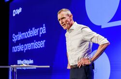 Bak oppdraget ligger behovet for modeller som offentlige og private virksomheter kan ta i bruk, og som bygger på norsk språk, norsk kultur og kunnskap om Norge. Men Wilfred Østgulen pekte også på at den internasjonale utviklingen gjør arbeidet viktigere av sikkerhetspolitiske grunner. Foto: Kilian Munch, Digitaliseringskonferansen Engasjert mann på talerstolen, bare skjorte og ikke jakke