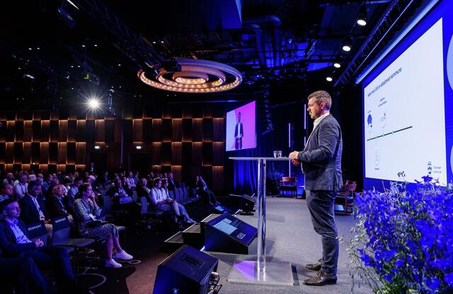 Selv om Stavanger er kåret til årets KI-kommune, understreket Lars Christian Tufte at kommunen ikke er ferdig. Foto: Kilian Munch, Digitaliseringskonferansen Mann på scenen, sett fra avstand og på siden.