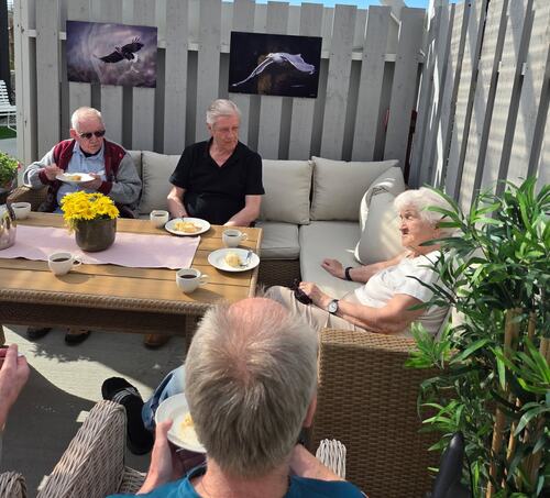 Beboerne nyter solen og de nye hagemøblene.