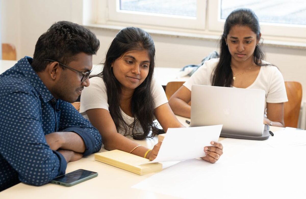 Arbeidsplassen er den viktigste læringsarenaen vi har, og den neste store lederoppgaven handler om læring, skriver Hege Ulveland. Foto: MD Jaeadure Rahman / Pexels Tre studenter sitter ved et bord i et lyst undervisningsrom. To leser et ark sammen, mens den tredje arbeider på en bærbar PC.