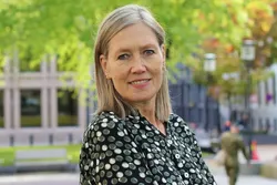 Det er ikke overraskende at gevinstene så langt er relativt beskjedne. Kunnskapsarbeid er komplekst, og KI er ikke like godt egnet til alle typer oppgaver, skriver Ellen Strålberg. Foto: Teknologirådet Smilende kvinne med langt lyst hår og blomstrete skjort fotografert utendørs.