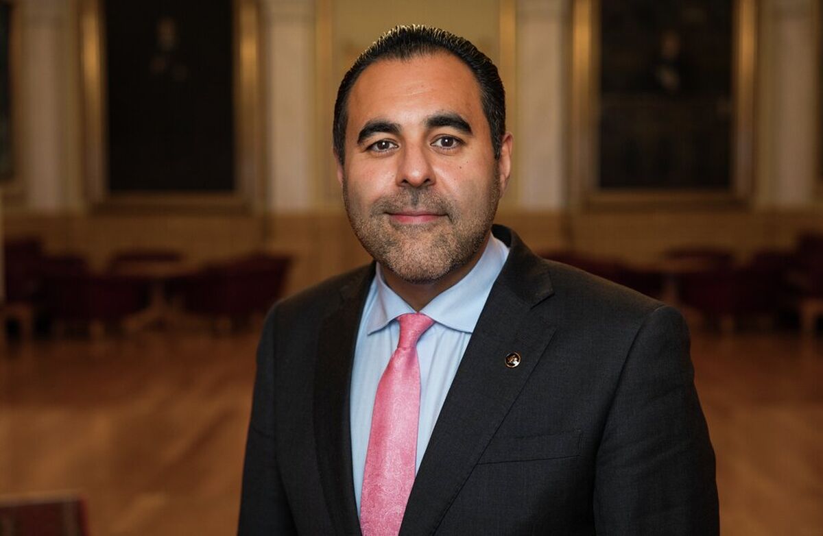 Stortingspresident Masud Gharahkhani avsluttet med å understreke at de høye norske tillitstallene er noe å være stolt av, men ikke noe samfunnet kan ta for gitt. – Demokrati er noe du må jobbe for hver eneste dag, understreket han. Foto: Stortinget Bildet viser Masud Gharahkhani. Han er opprinnelig fra Iran, og har mørkt hår og brune øyne. Han er ubarbert. Bildet er tatt på Stortinget, vi kan se deler av dressjakka, som er mørk, og den blå skjorten og det rosa slilpset.