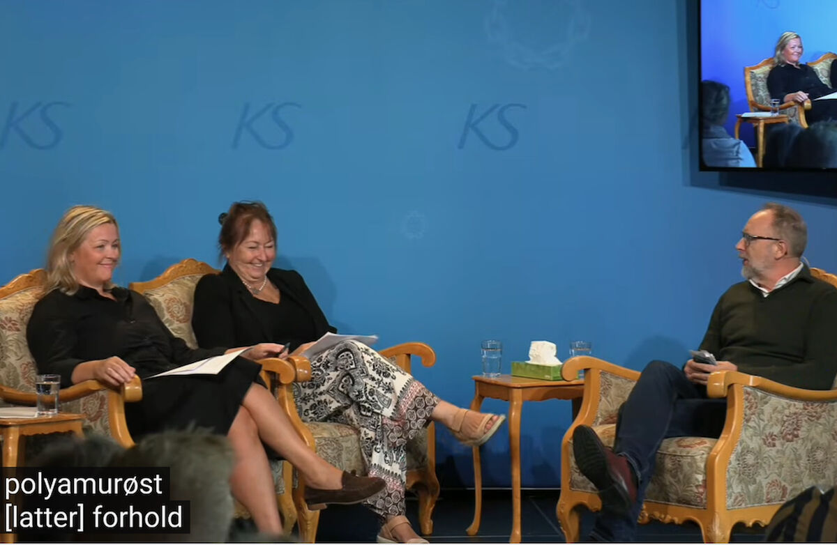 Psykolog og parterapeut Frode Thuen ledet «parterapien» mellom arbeids- og inkluderingsminister Kjersti Stenseng og KS-leder Gunn Marit Helgesen – med mye humor, men med et alvorlig bakteppe om framtiden for Nav-partnerskapet. Foto: Klipp fra video av samtalen Deltakerne på scenen, avslappet i hver sin stol.