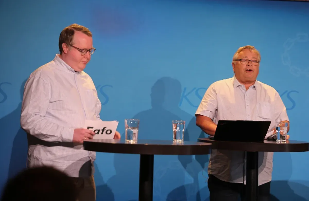 Leif Moland (f.h.) og Kjetil Bråthen fra Fafo på scenen under forskningsfrokost på Arendalsuka 2026. Foto: KS To menn på scenen, hvite skjorter, litt fyldige.