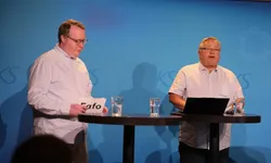 To menn på scenen, hvite skjorter, litt fyldige.