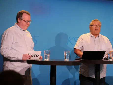 To menn på scenen, hvite skjorter, litt fyldige.