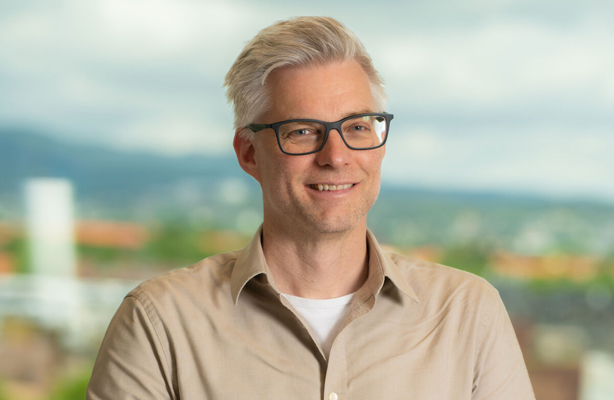 Blid mann med grått hår, ser ungdommelig ut.
