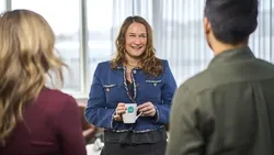 Bildet viser Ingvill som smiler i en samtale med to personer. De to har ryggen til kamera.