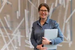 Bente Leirvik Dahle leder Fremtidens innkreving i Skatteetaten. Målet er å gjøre det enklere for innbyggere og virksomheter å få oversikt over og betale det de skylder. Foto: TUM Studio. Bilde av Bente mens hun går i en korridor el. i et kontormiljø.