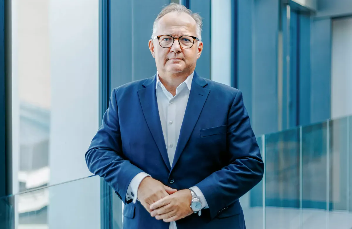 Geir Arne Olsen, norgessjef i Netcompany, mener Norge må gå fra å være en storforbruker av teknologi til å bli en aktiv utvikler av digitale løsninger. Foto: Netcompany. Portrettbilde av Olsen i et kontormiljø