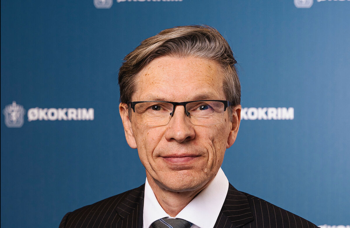 Portrettbilde av Gunnar. Han er alvorlig. Bakgrunnen er blå med Økokrims logo og løve.